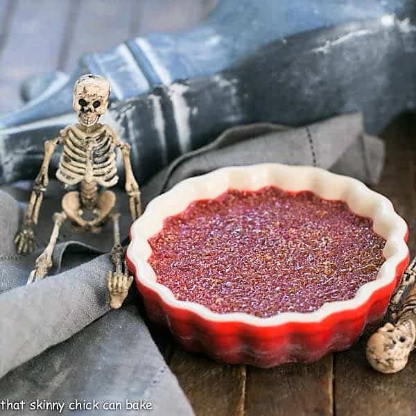 Bloody Crème Brûlée - The classic vanilla custard with burnt sugar topping and a ghoulish twist! Bloody Crème Brûlée in a red ramekin.