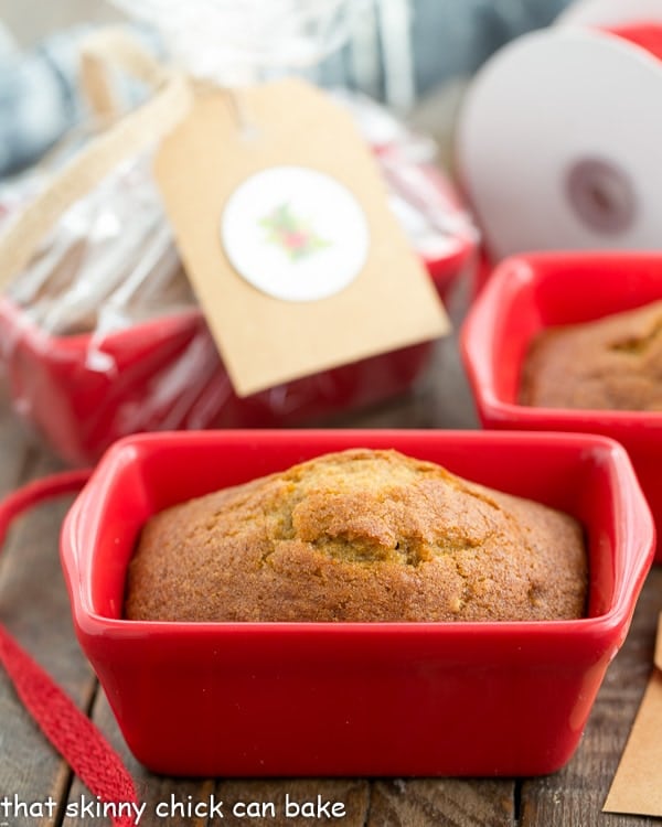 Mini Pumpkin Breads - Perfect for gifting throughout the holiday season! Mini Pumpkin Breads in a small red ceramic loaf pan.