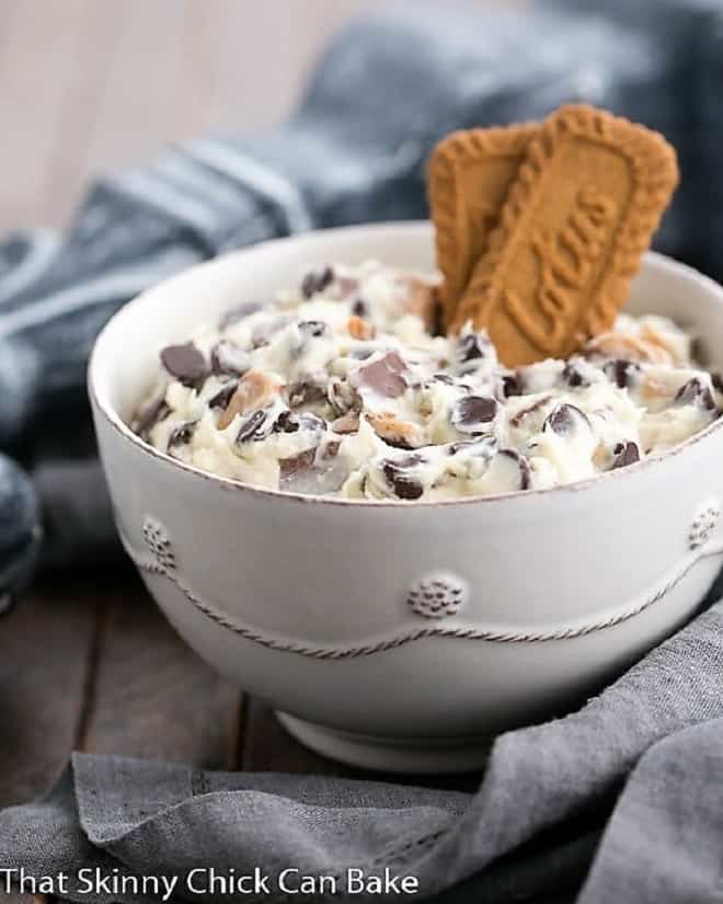 Chocolate Chip Cookie Dough Dip - A dreamy dip filled with chocolate chips and toffee pieces! Chocolate Chip Cookie Dough Dip in a white bowl garnished with 2 Biscoff cookies.