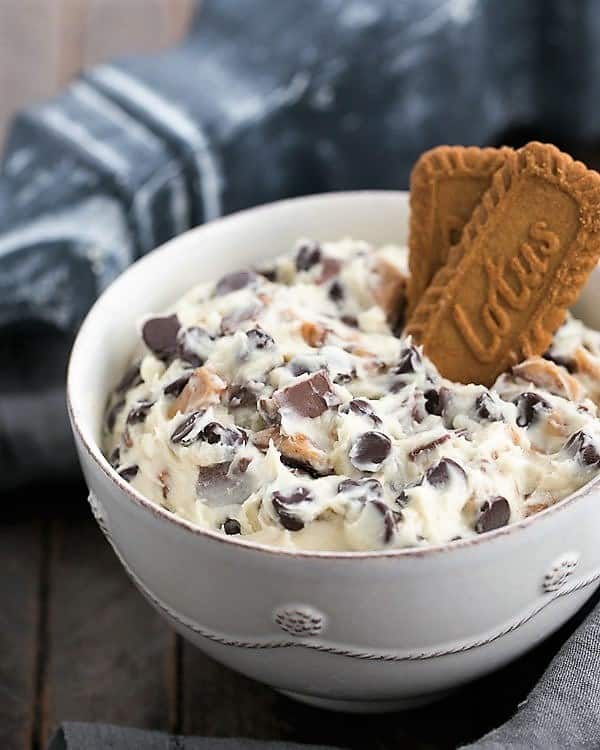 Chocolate Chip Cookie Dough Dip - A dreamy dessert dip filled with chocolate chips and toffee pieces! Chocolate Chip Cookie Dough Dip in a white ceramic bowl.