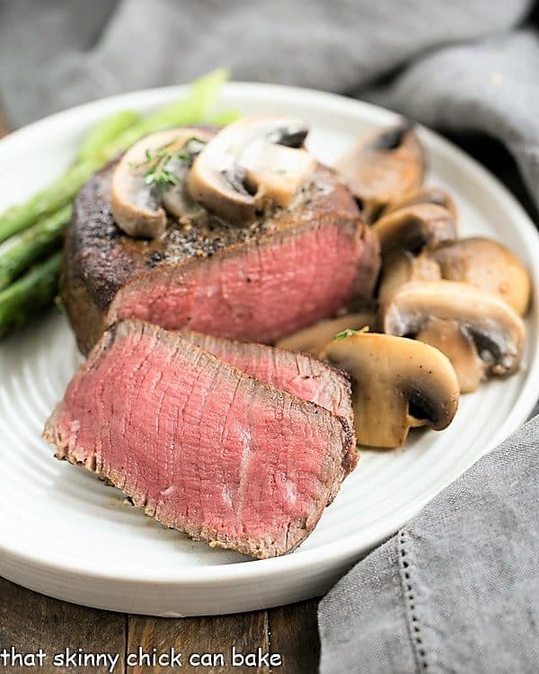 Mushroom Topped Pepper Steak sliced on a white dinner plate.