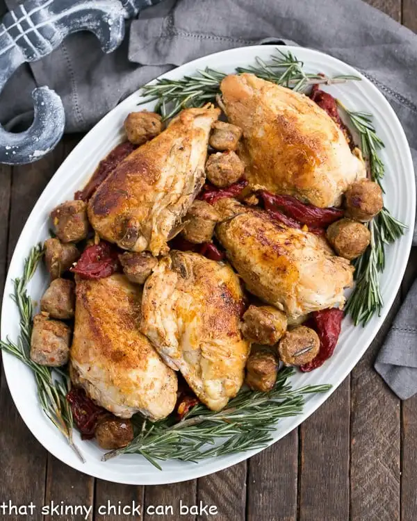 Chicken Scarpariello with Sausage - A superb Italian chicken entree with an extraordinary depth of flavor from garlic, herbs and white wine Overhead view of Chicken Scarpariello on a white platter garnished with fresh rosemary.