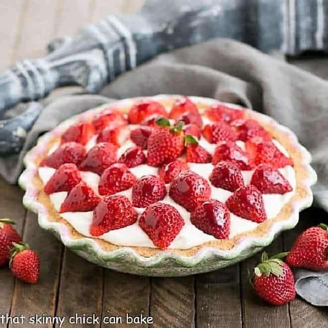 Strawberry Cream Pie  in a cerami pie plate surrounded by fresh strawberries