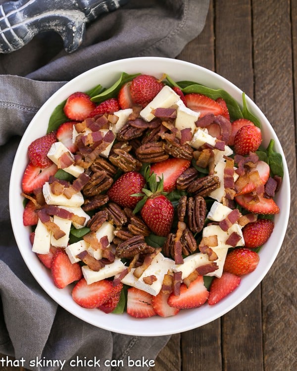 Strawberry Bacon Brie Salad - A spectacular combination of ingredients tossed in a strawberry balsamic vinaigrette Strawberry Bacon Brie Salad in a round white serving bowl from overhead.
