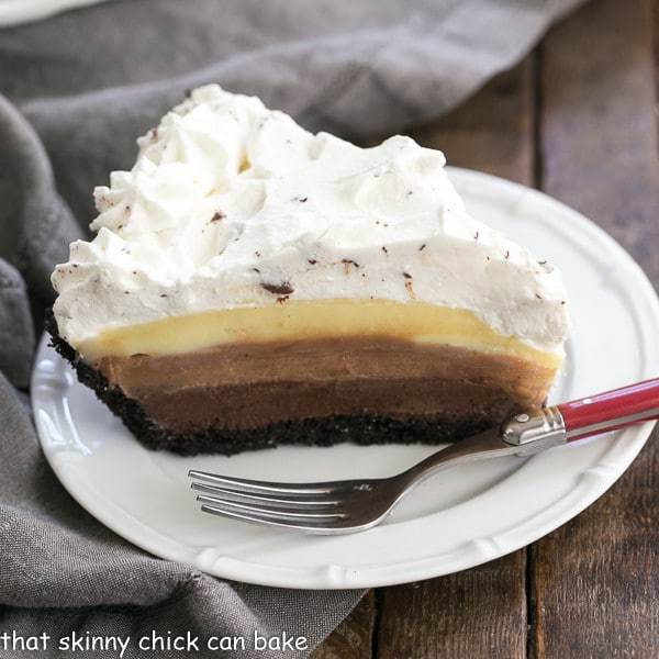 Triple Chocolate Layer Pie Recipe slice on a white plate with a red handled fork.