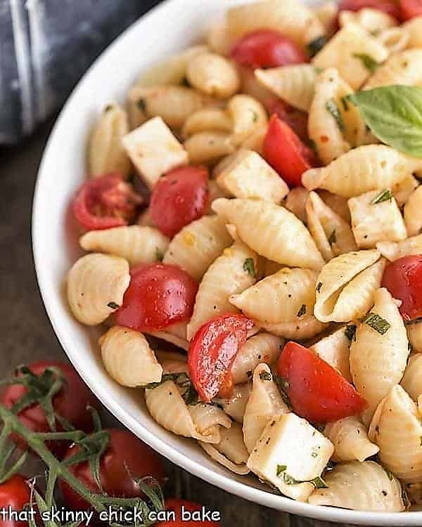 Tomato Basil Pasta Salad with Mozzarella & Fontina close view in a white serving bowl.