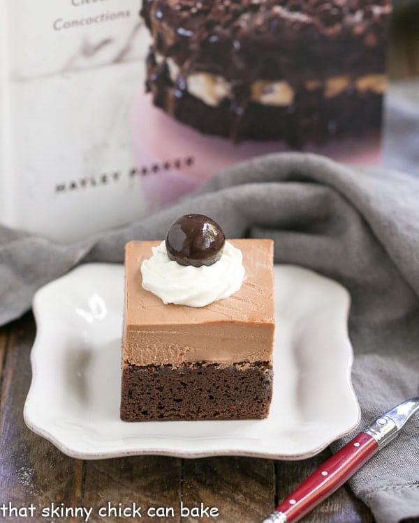 French Silk Pie Brownies - A spectacular 2 in one dessert that's a cinch to prepare! French Silk Pie Brownies on a white ceramic plate with a red handled for