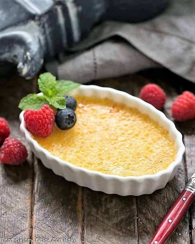 White Chocolate Crème Brûlée - An ultra creamy custard infused with white chocolate and topped with burnt sugar White Chocolate Crème Brûlée in a white ramekin.