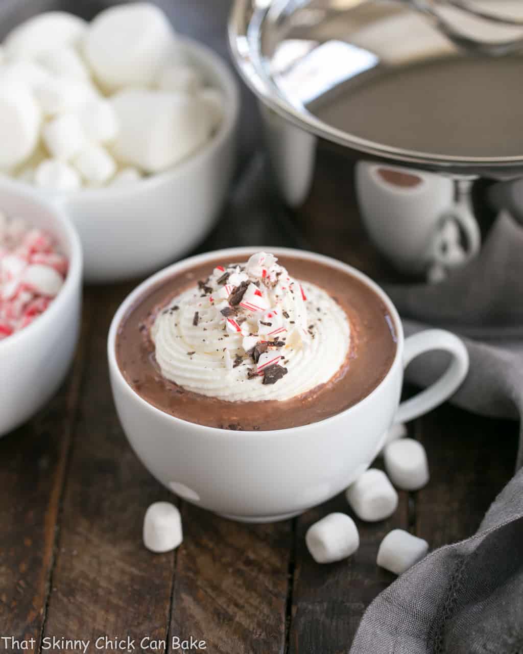 Easy Peppermint Hot Chocolate in a mug topped with whipped cream and candy cane shards.