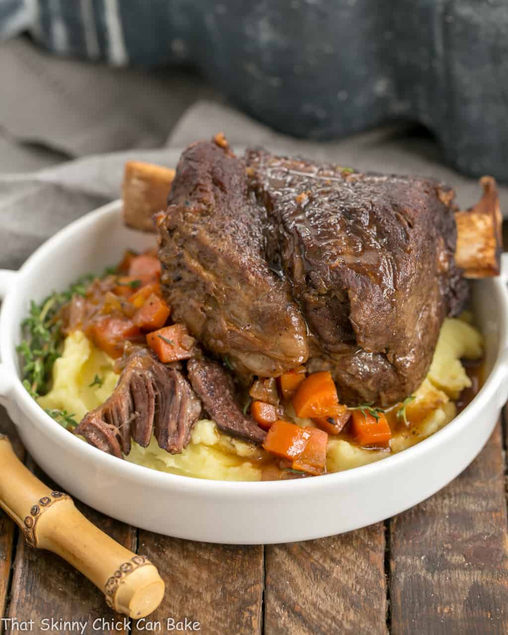 Instant Pot Beef Short Ribs - A quick cooking time make these short ribs a perfect dinner any day of the week Instant Pot Beef Short Ribs on a round white plate over mashed potatoes and carrots.