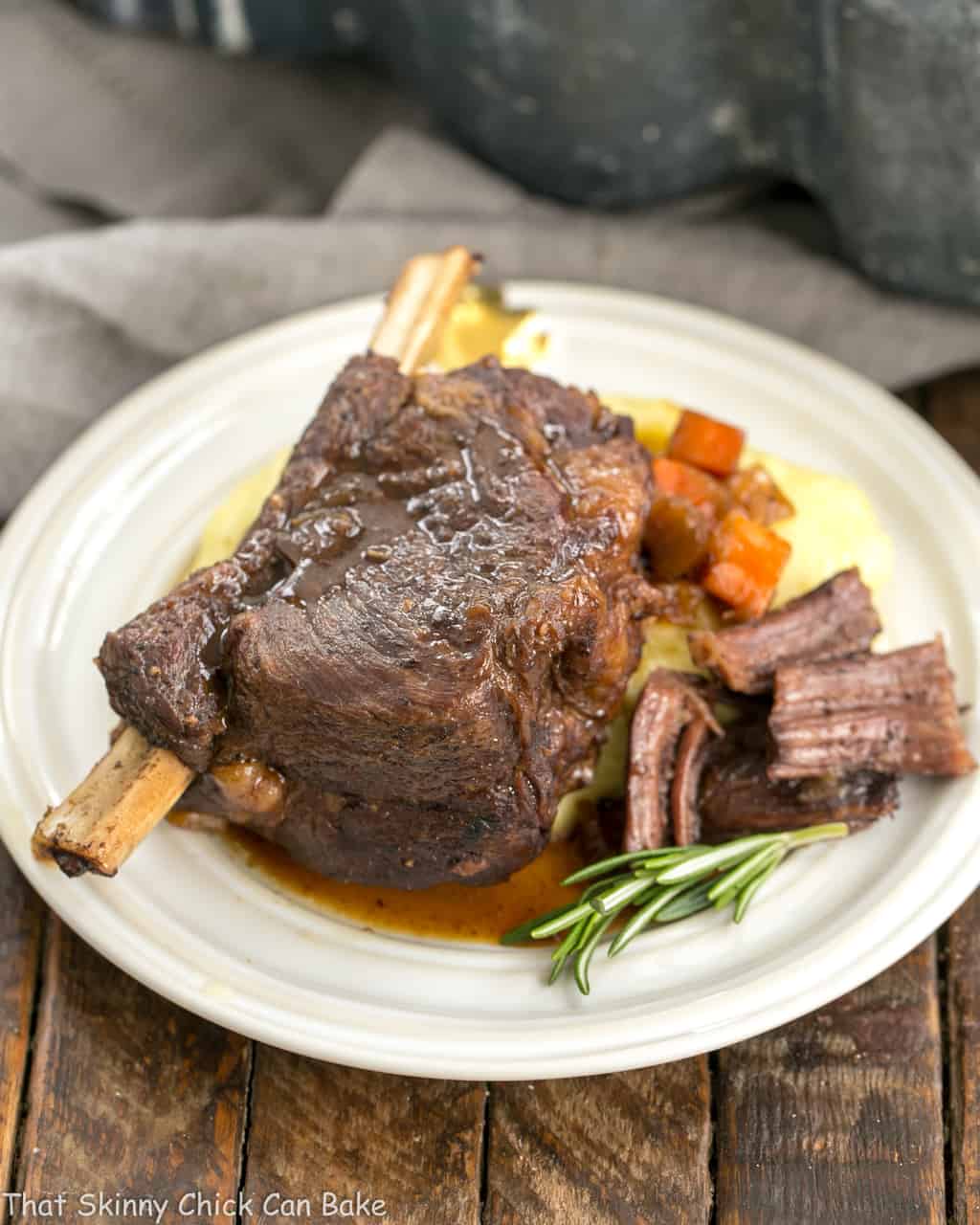 Instant Pot Beef Short Ribs - A quick cooking time make these short ribs a perfect dinner any day of the week Instant Pot Beef Short Ribs on a round white plate garnished with rosemary.