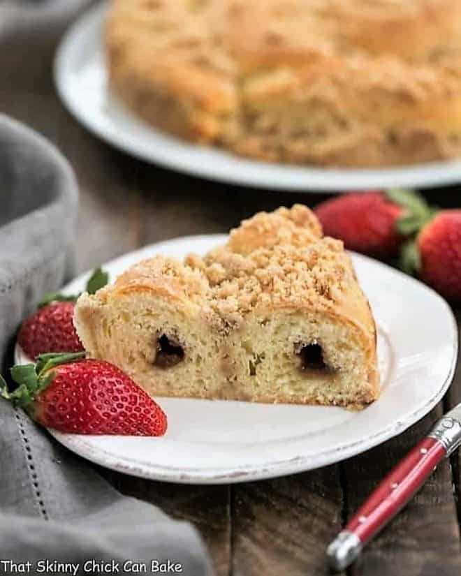 Slice of Streusel Coffee Cake Recipe on a white plate with strawberries.