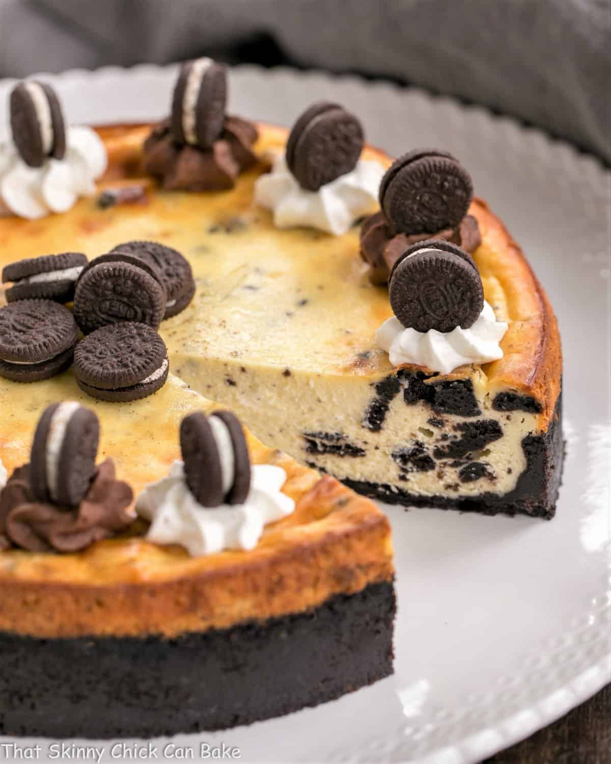 Oreo Cheesecake with Oreo Cookie Crust - a double dose of Oreos in this incredibly rich, delicious dessert Oreo Cheesecake with Oreo Cookie Crust with slice gone on white serving plate.