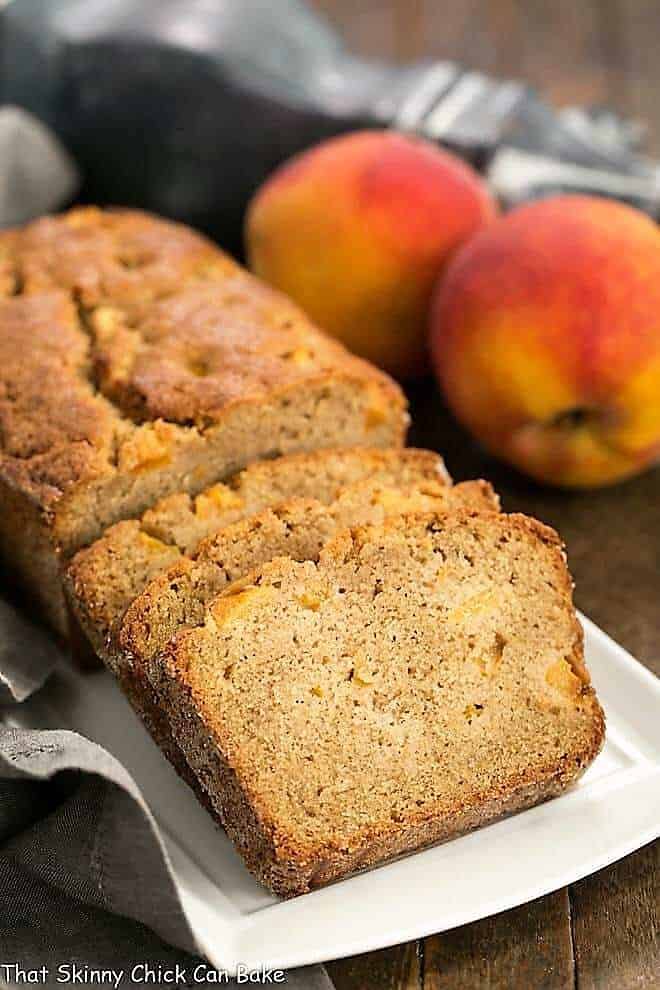 Fresh Southern Peach Bread - a cinnamon spiced quick bread chock full of diced peaches! Fresh Southern Peach Soda Bread sliced on a white rectangular tray.