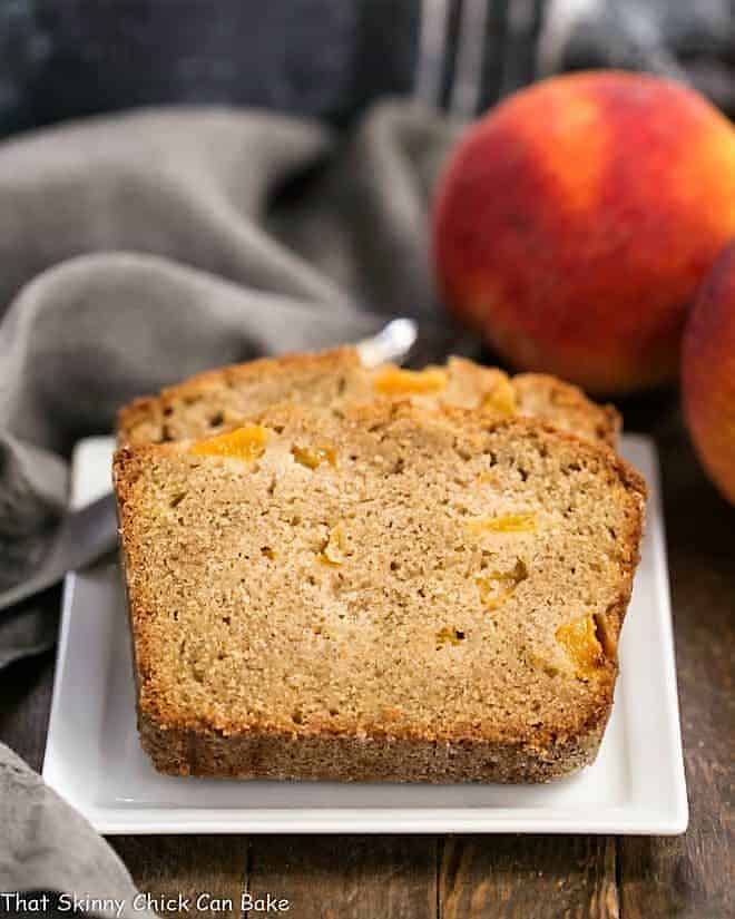 Fresh Southern Peach Bread - a cinnamon spiced quick bread chock full of diced peaches! Fresh Southern Peach Bread slices on a square, white ceramic plate.