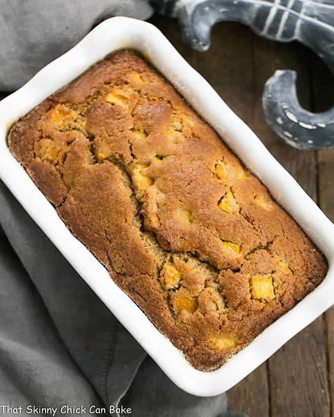 Fresh Southern Peach Bread - a cinnamon spiced quick bread chock full of diced peaches! Fresh Southern Peach Bread in a white ceramic loaf pan.