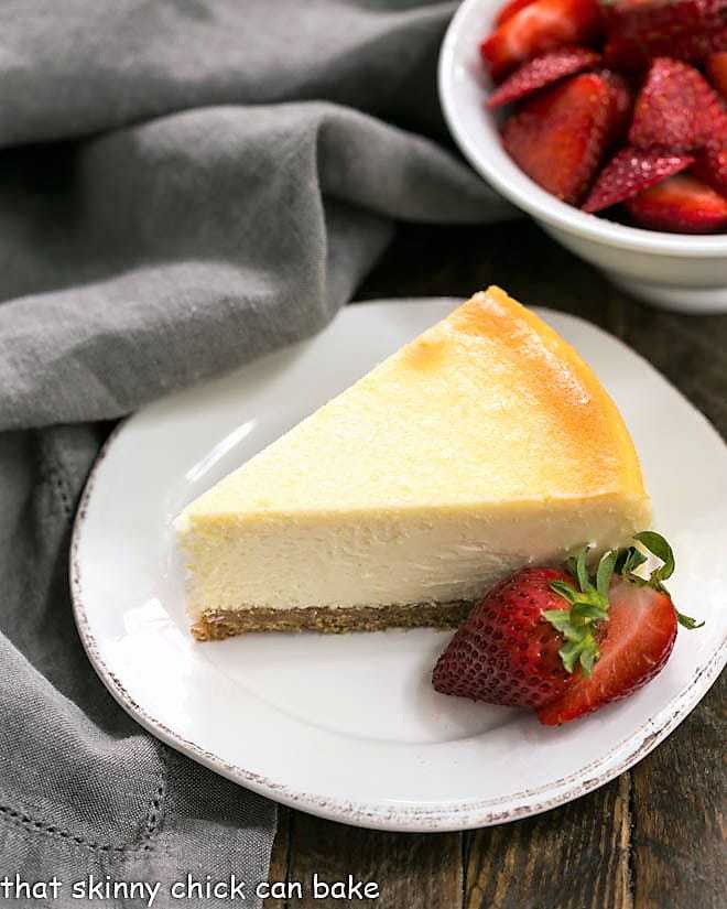 Perfect vanilla cheesecake with strawberries on a white plate.