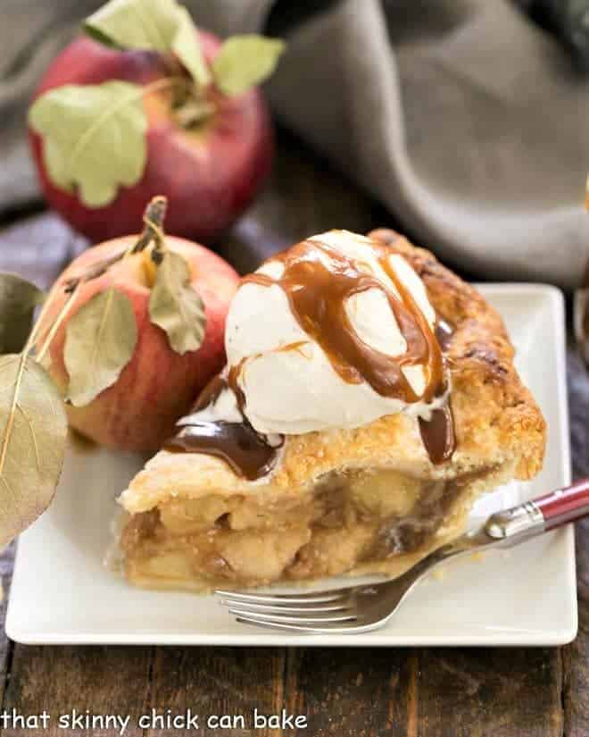 Caramel Apple Pie - a fabulous homemade apple pie enhanced by caramel sauce added to the filling! Caramel Apple Pie on a square white plate topped with ice cream and caramel sauce.