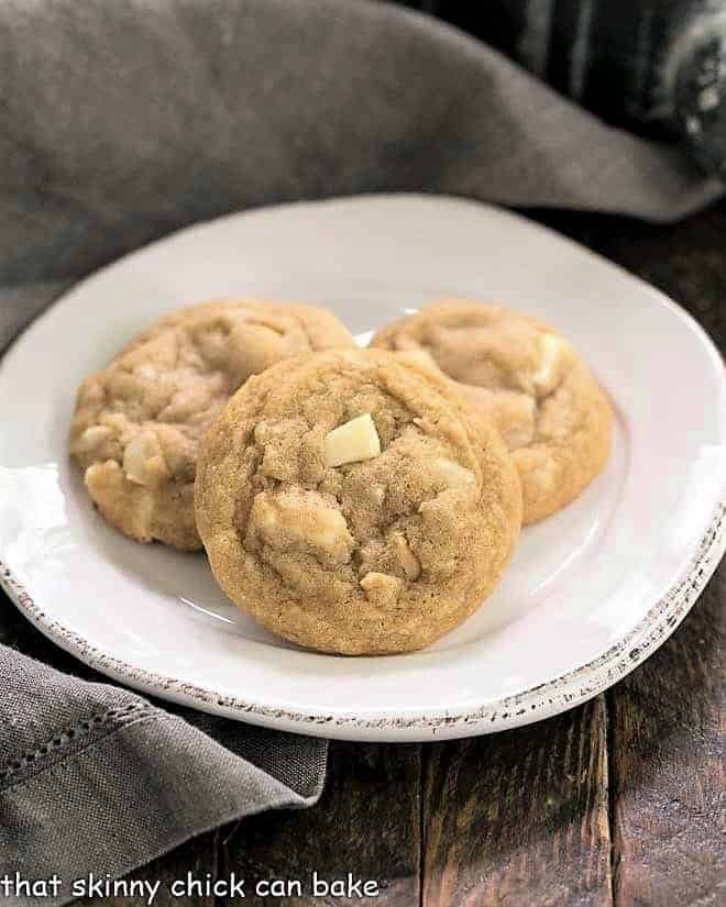 3 white chocolate macadamia nut cookies on a white plate