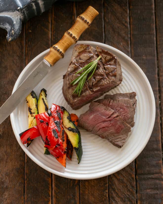 Overhead view of Filets with Red Wine Balsamic Sauce on a white plate with vegetables.