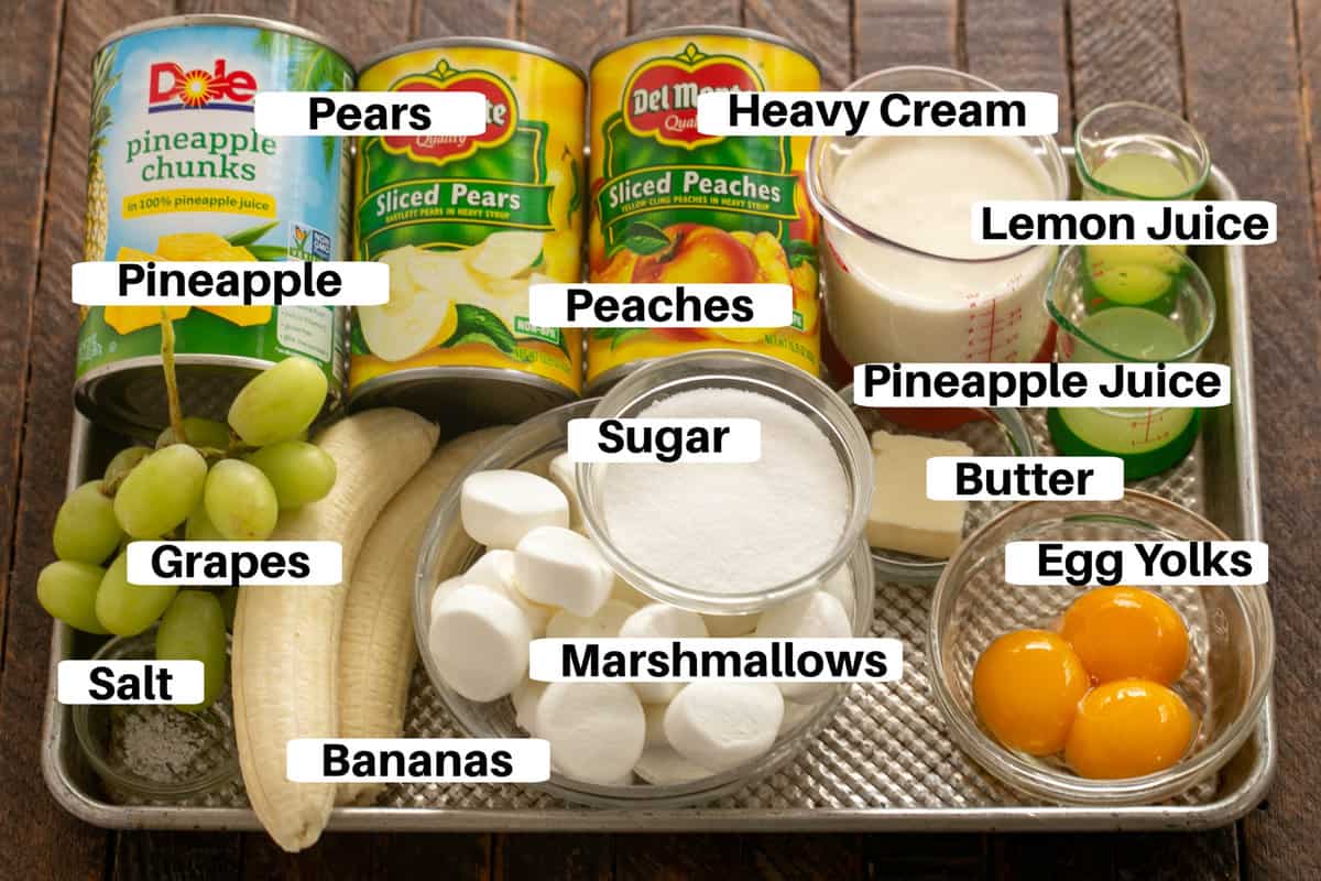 Overnight fruit salad ingredients with labels on a metal sheet pan.