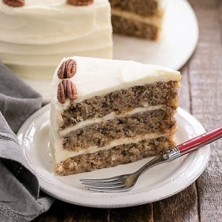 hummingbird cake slice on a white plate with a fork