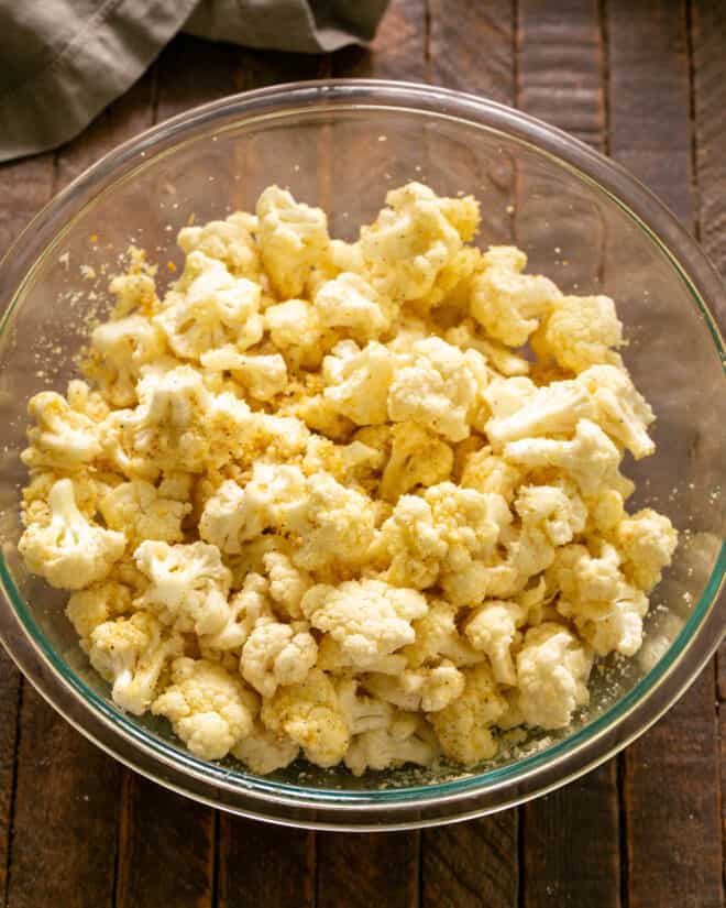 Bowl of cauliflower tossed with oil.