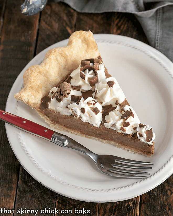 Chocolate Pie Recipe with Frangelico - the most luscious chocolate pie you'll ever encounter!! Overhead view of a slice of french silk pie with a red handle fork.