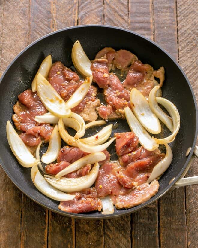 Marinated Pork and Onions in a skillet.