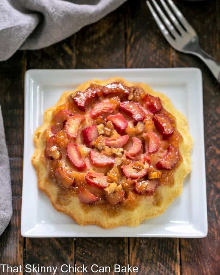 Overhead view of a rhubarb baby cake on a square white plate