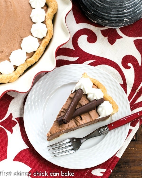 Overhead view of a slice of French Silk Pie on a white plate with a red handled fork.