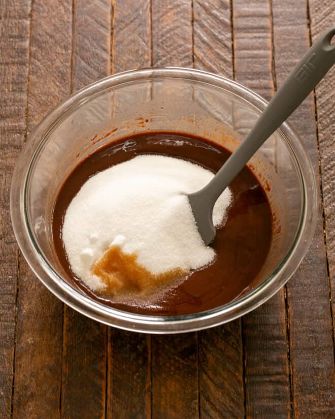 Sugar added to melted chocolate, then eggs one at a time and vanilla.