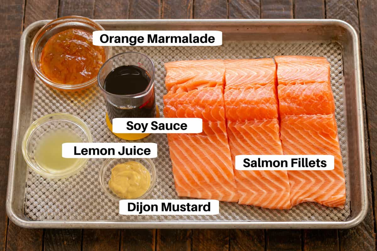 Salmon and marinade ingredients on a metal sheet pan.